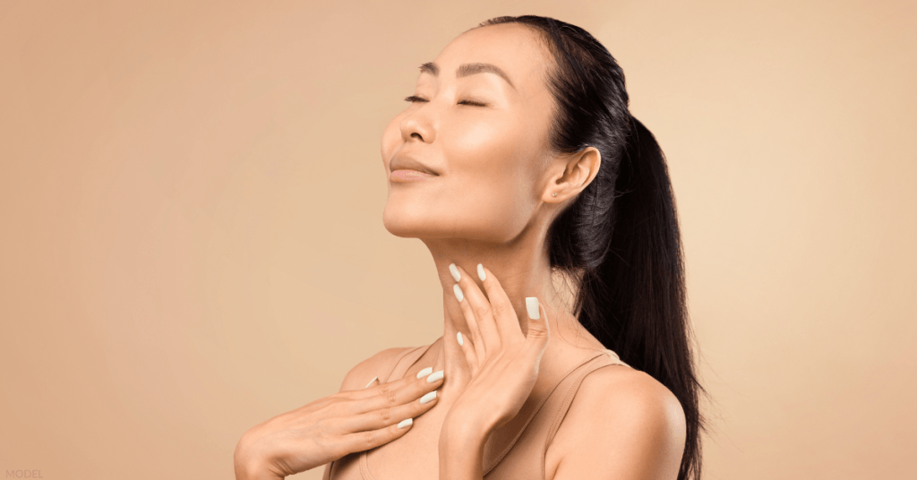 Woman with her hands touching her neck (model)